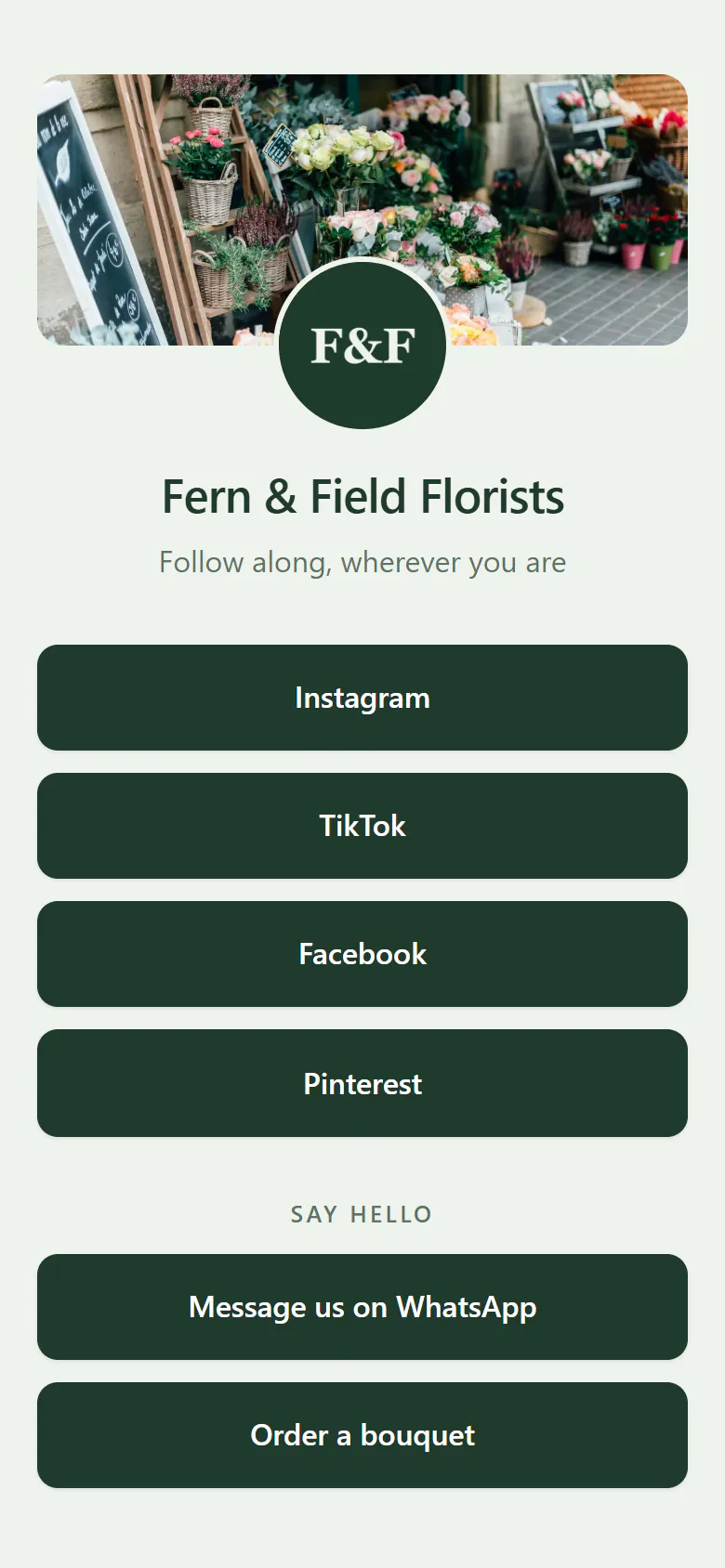 A florist’s social media page on a phone, dark green on sage: a cover photo of buckets of flowers outside the shop, the round F&F logo, a button each for Instagram, TikTok, Facebook and Pinterest, then WhatsApp and ordering a bouquet under a Say hello heading.